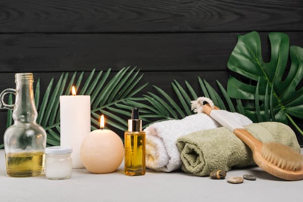 a table with oil jrs, candles and towels for a relaxing massage